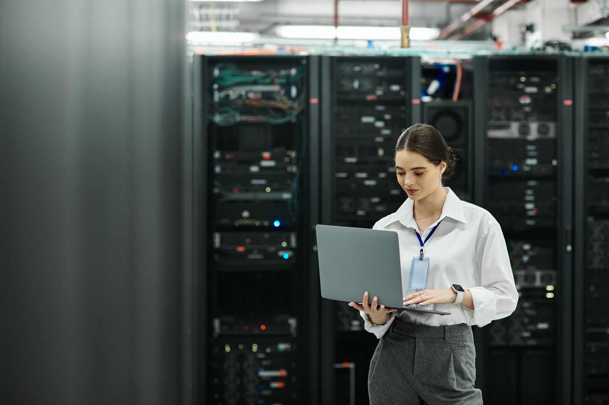 A technician working on a laptop in a data center aisle